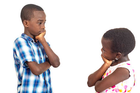 two kids thinking and looking at each other with their hands on their chins.の写真素材