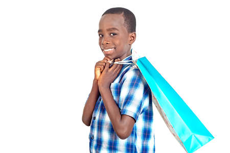 cute little boy standing aside and holding a shopping bag smiling.の写真素材