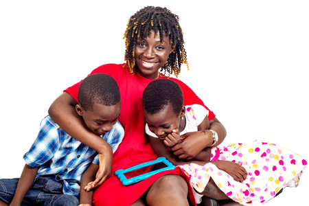 Happy beautiful mom and children looking together at the digital tablet at home.