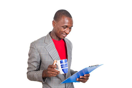 handsome adult businessman reading a clipboard and holding a cup of coffee.の写真素材