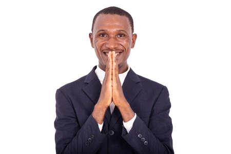 adult businessman holding hands folded against lips and smiling at camera.の写真素材