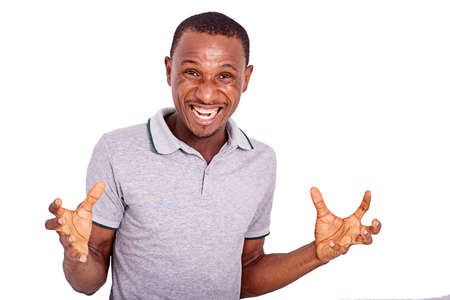 handsome young man standing inside furious with rage with an aggressive expression and arms raised.の写真素材