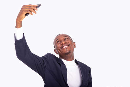 handsome happy adult businessman raising his cellphone up and taking photos while smiling.の写真素材