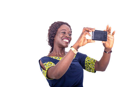 beautiful happy adult woman standing in loincloth taking photo on mobile phone smiling.の写真素材