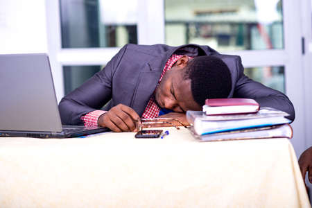 handsome businessman in suit sitting at desk while sleeping.の写真素材
