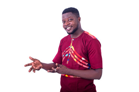 a handsome man wearing a loincloth shirt standing on a white background smiling and gesturing.