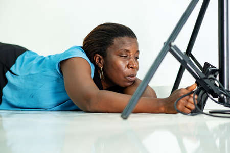 beautiful tired mature woman lying on the floor at home using a mobile phone.の写真素材