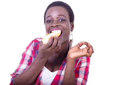 beautiful young woman sitting at the table eating a piece of bread.の写真素材