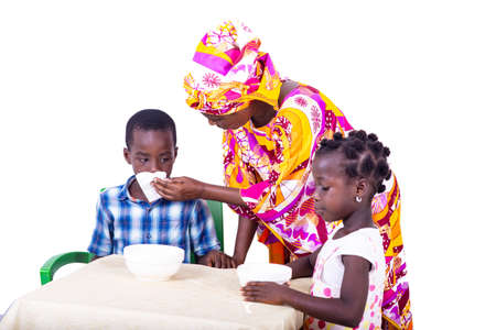 adult mother with her grandchildren seated at the table to have breakfast.の写真素材