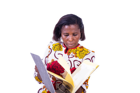 a mature businesswoman in corsage standing on white background looking for document in a filing cabinetの写真素材