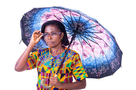 beautiful adult woman standing under an umbrella holding the frame of glasses looking aside.