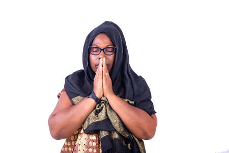 muslim mature woman with closed eyes praying to god with hands together.の写真素材