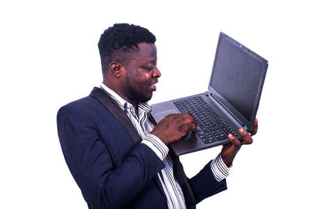 young businessman wearing an elegant suit and working on the laptop while smiling.の写真素材