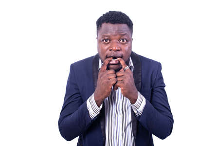 young frightened businessman wearing an elegant suit and biting his fingers while looking at the camera.の写真素材