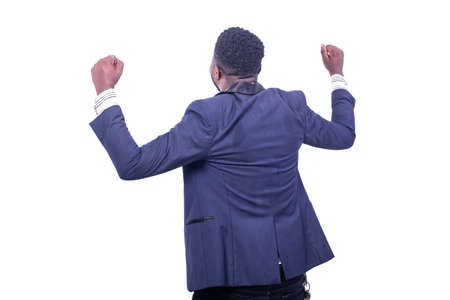 rear view of a young businessman wearing a suit making a winner while raising his hands.の写真素材