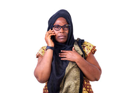 Serious mature woman with glasses talking on the cellphone.の写真素材