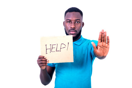 young man holding a sheet of paper with written help and making a stop gesture.