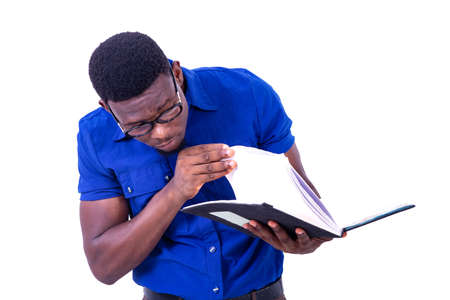 handsome young serious businessman wearing glasses, turning pages of notebook.の写真素材