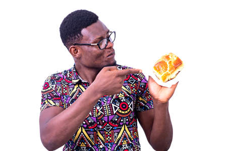 portrait of handsome young man having breakfast while pointing finger at croissant.の写真素材