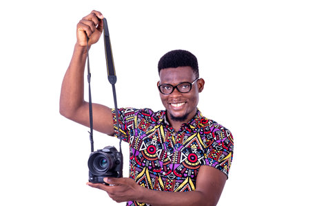 portrait of handsome young man photographer holding camera while smiling at camera.