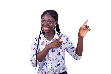 portrait of a beautiful young woman pointing fingers aside while smiling at the camera.の写真素材