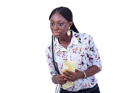 portrait of a beautiful young female tourist holding a paper map while looking aside.
