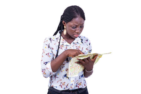 portrait of a beautiful young serious tourist woman looking at a paper map.の写真素材