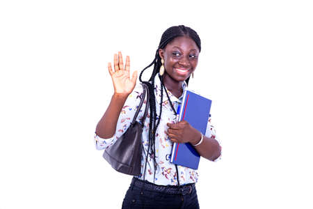 portrait of a beautiful young happy student woman raising hand to greet while smiling.の写真素材
