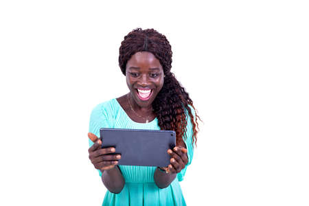 portrait of a beautiful happy young woman looking at screen of a digital tablet while smiling.の写真素材