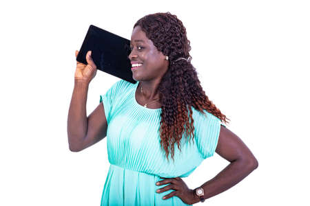 portrait of a beautiful young woman wearing a beautiful green dress, talking on a digital tablet while smiling.の写真素材
