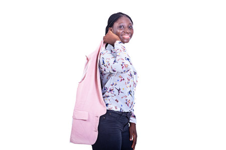 a beautiful young businesswoman standing on white background holding jacket on her back looking at the camera while smiling.の写真素材