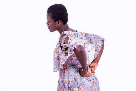 portrait of a beautiful young woman suffering from kidney pain, touching the kidneys with hands.の写真素材