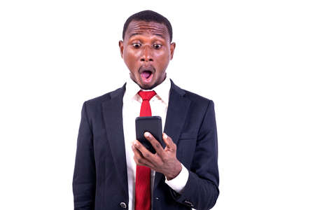 a businessman standing on white background looking at cellphone with surprised air.の写真素材