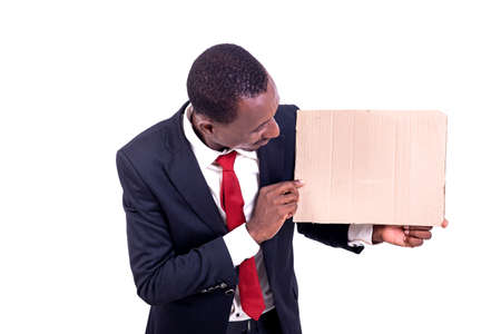 a smiling businessman standing on white background looking at an empty paper.の写真素材