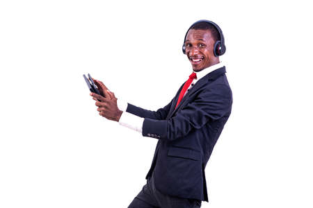 a businessman standing on a white background communicating using a headset and a tablet looking at the camera in profile, smiling.の写真素材