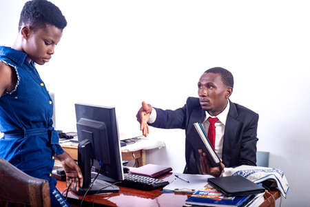 serious adult businessman telling woman to sit on chair at office.の写真素材