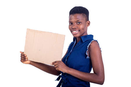 portrait of a beautiful girl holding a piece of blank cardboard while smiling at the camera, isolated on white background.の写真素材