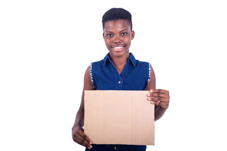 portrait of a beautiful girl holding a piece of blank cardboard while smiling at the camera.の写真素材