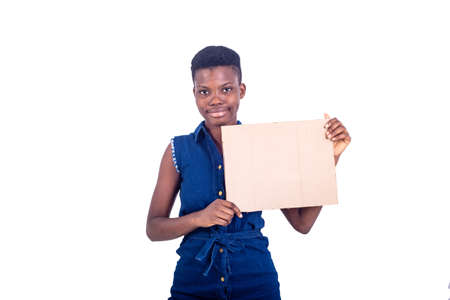 portrait of a beautiful girl holding a piece of blank cardboard while smiling at the camera, isolated on white background.の写真素材