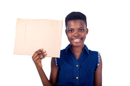 portrait of a beautiful girl holding a piece of blank cardboard while smiling at the camera, isolated on white background.の写真素材
