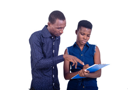 portrait of a young businessman with a secretary working together on the clipboard.の写真素材