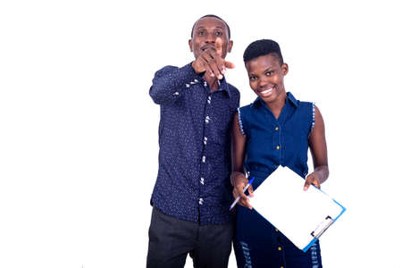 portrait of a young businessman pointing the finger forward and woman holding a clipboard while smiling.の写真素材