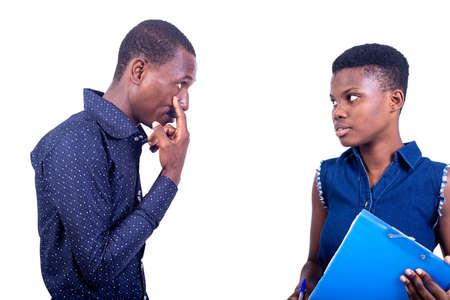 portrait of a young businessman with a woman chatting together. man pointing finger to eye.の写真素材