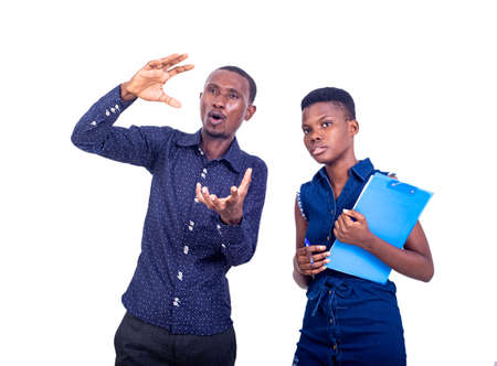 young businessman gesturing his hands for something to a secretary holding a clipboard.の写真素材