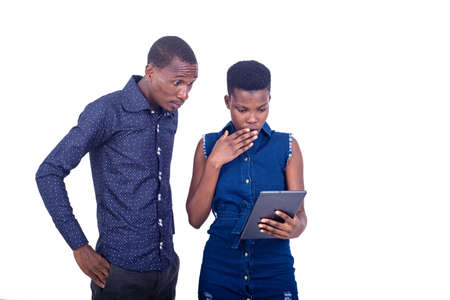 portrait of a surprised young man and woman using a digital tablet.の写真素材