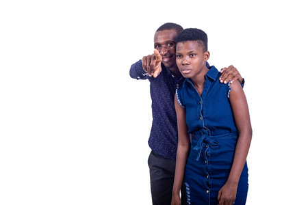 portrait of a handsome young man showing a way to a woman while pointing the finger aside while smiling.の写真素材