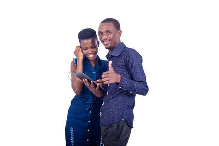 man and woman listening to music together with headphones on a digital tablet. man showing his thumb.の写真素材