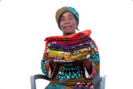 portrait of a beautiful woman sitting on a chair and holding several traditional loincloths in her...