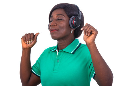 beautiful mature woman listening to music with her wireless headphones with closed eyes enjoying the...