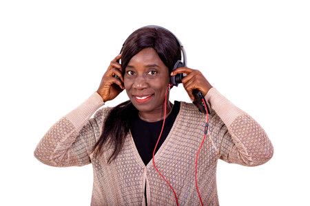 portrait of a beautiful mature woman listening to music on headphones smiling.